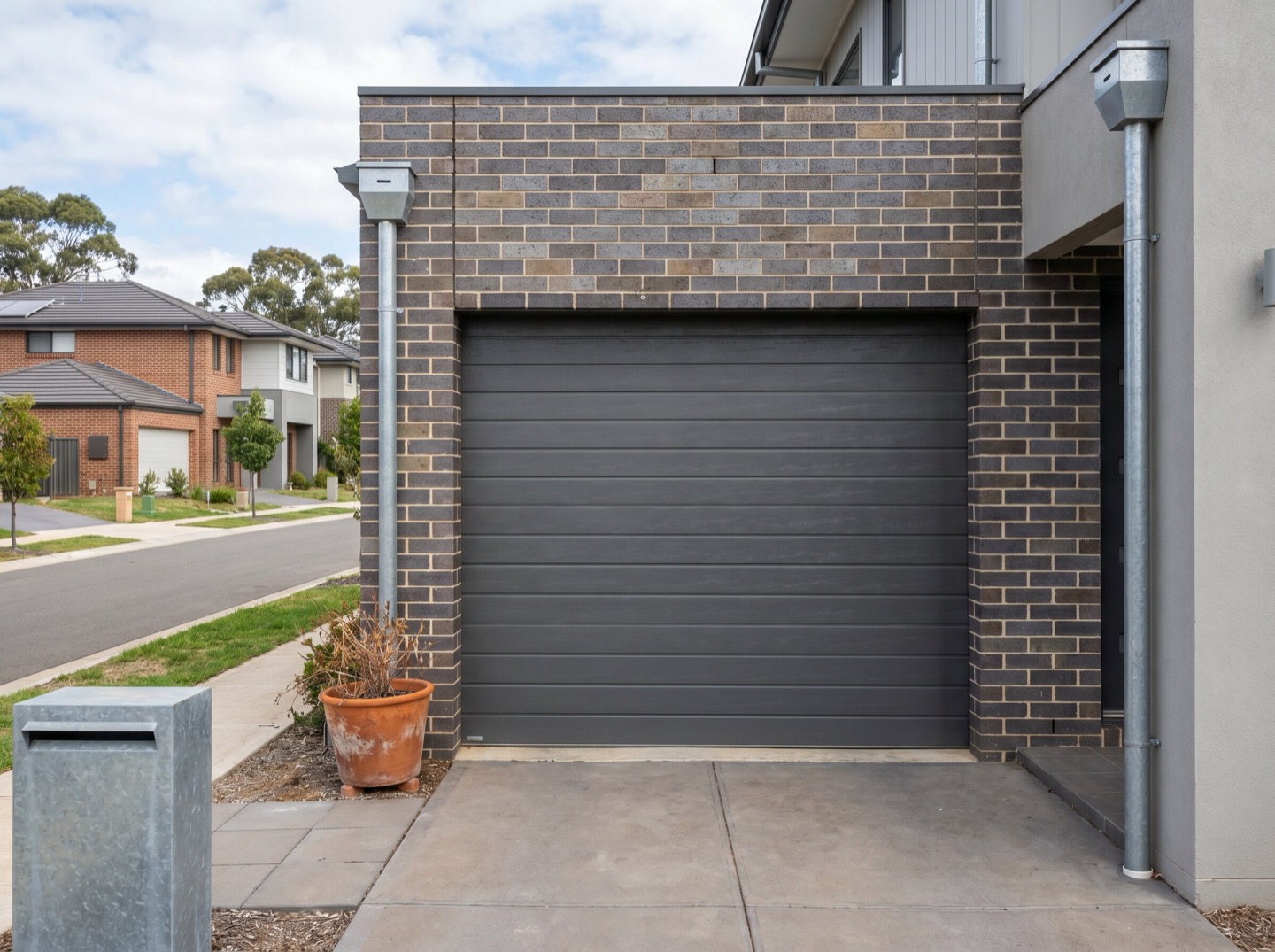A modern sectional panel-lift garage door on a Newcastle brick home