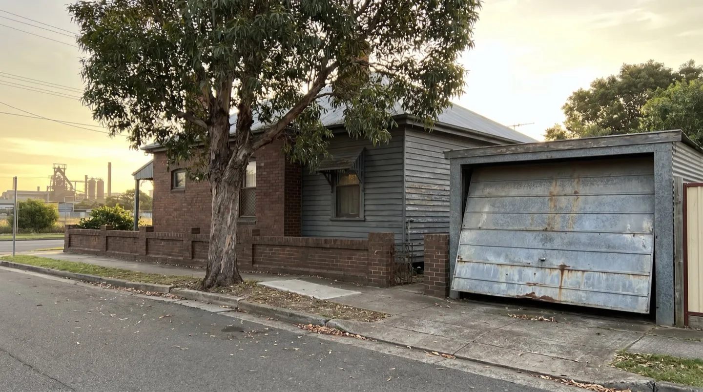 An established Mayfield brick-and-weatherboard cottage with an ageing galvanised tilt door, the old steelworks on the horizon